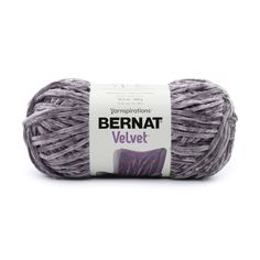 bernat velvet yarn ball in grey and purple colors on a white background with the label