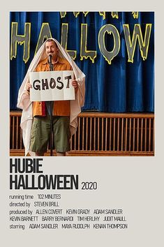 a man standing in front of a microphone holding a sign that reads ghost hubie halloween