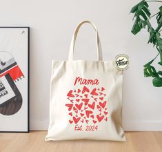 a tote bag sitting on top of a wooden floor next to two framed pictures