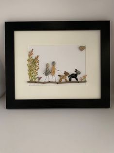 there is a framed picture with three birds and two dogs on the same branch, in front of a white wall