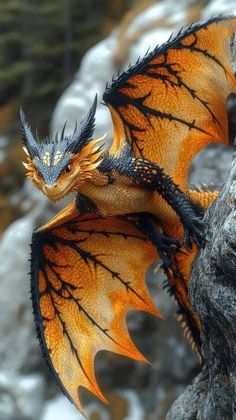 an orange and black dragon figurine sitting on top of a rock