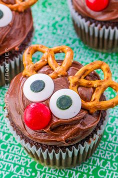 cupcakes with chocolate frosting and pretzels decorated as reindeer's noses