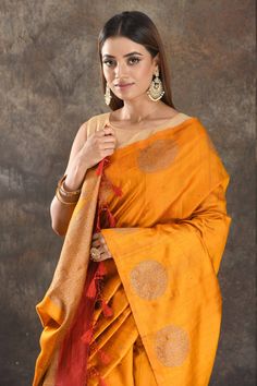 Be vision of elegance on special occasions in this mango yellow tussar Banarasi saree. The saree is enhanced with antique zari buta and pallu. It comes with a red blouse piece. Disclaimer: The actual product may vary slightly from the image. These are custom orders, hence expect slight variation in color, placement of the motif or buta. ESTIMATED DELIVERYBecause this is a custom order, it would take about 4 weeks from the date of purchase. RETURN POLICYThis product is a custom order and cannot b Banarasi Sari, Mango Yellow, Sarees Banarasi, Embroidered Sarees, Fashion Journals, Red Blouse, Traditional Fabric, Banarasi Saree, Indian Saree