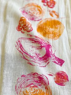 an orange and pink design on a white table cloth