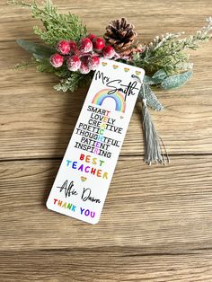 a bookmark with an inspirational quote on it next to some flowers and pine cones