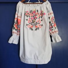 Nwot Off The Shoulder Long Sleeve Embroidered Cotton Dress. Muted Baby Blue Color With Cream, Fluorescent Orange, And Fluorescent Pink Flowers. Long Puff Sleeve With Ruffle At The Wrist. Features A Wide Hem And Two Side Pockets On This Slip On Mini. Elastic At Neck, Shoulders, And Wrist. Note - Some Embroidery Missing On The Left Sleeve Stripe Spring Cotton Embroidered Long Sleeve Dress, Spring Cotton Embroidered Dress, Long Sleeve Cotton Embroidered Spring Dress, Long Sleeve Cotton Embroidered Dress For Spring, Spring Multicolor Embroidered Tunic Dress, Long Sleeve Cotton Dress With Multicolor Embroidery, Casual Spring Embroidered Dress For Brunch, Casual Embroidered Dress For Spring Brunch, Cotton Embroidered Long Sleeve Dress With Multicolor Embroidery