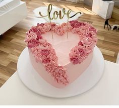 a heart shaped cake with pink flowers on top