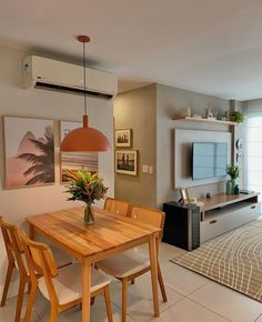 a dining room table and chairs in front of a television