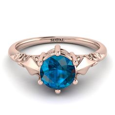 an oval blue topaz ring with two leaves on the band and a diamond accent