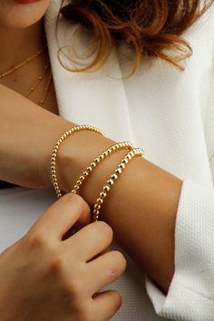 14k Gold Filled Tarnish Resistant Beaded Ball Bracelet.  A Minimalist Gold Bracelet That You Can Wear on Its Own or Layer up. Your Perfect Everyday Companion. If You Are Looking for A Quality Bracelet that Keeps its Shine, this is Ideal For You. Stretch to fit variety of wrist sizes Tarnish Resistant and Hypoallergenic Bracelet. DIMENSIONS Material: 14k Gold Filled Ball Bead Sizes 1) 3mm 2) 4mm 3) 5mm Bracelet Length: Fits comfortably for up to 7.5 Inch Wrist diameter What is 14K Gold Filled? '' Tiny Beads Bracelets For Jewelry Making, Elegant Stretch Bracelet With Tiny Beads, Dainty Beaded Charm Bracelet With Round Beads, Elegant Beaded Charm Bracelet For Jewelry Making, Dainty Beaded Gold Bracelet, Dainty Bracelet With Spacer And Round Beads, Elegant Beaded Bracelets With Polished Beads, Elegant Chain Bracelet With Gold Beads, Elegant Gold Stretch Bracelet With Tiny Beads