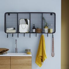 a kitchen with two metal racks holding towels and utensils on the wall next to a sink