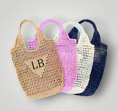 three different colored bags with the letter b on them, one in blue, one in pink and one in white