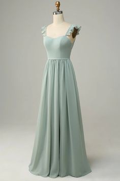 a light green dress on a mannequin with ruffled shoulders and pleated skirt