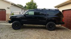 a black truck parked in front of two garages