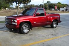 a red pick up truck parked in a parking lot