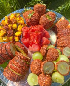 a platter filled with different types of food on top of a blue plate covered in fruit