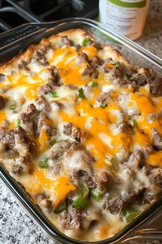 a casserole dish with meat, cheese and green peppers in it on a counter