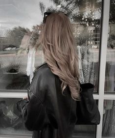 a woman standing in front of a window with her back to the camera