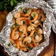 cooked shrimp in foil with parsley on the side, ready to be served for dinner