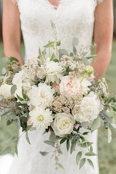 a bridal holding a bouquet of white and pink flowers