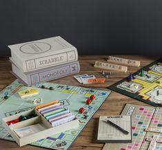 the board game scrabble is set up on a table next to two books