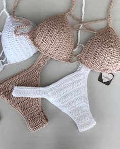 three crocheted bikinisuits and a keychain on a gray surface