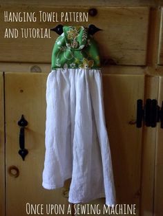 a green and white dress hanging from a hook on a wooden door with the words once upon a sewing machine