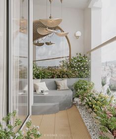 an outdoor seating area with plants and flowers on the floor next to a large window