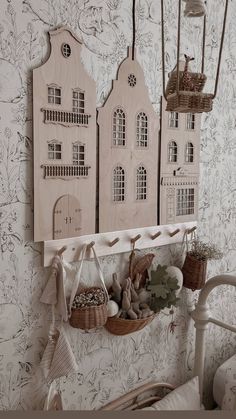 a white shelf with baskets and decorations hanging from it's sides in front of a wallpapered wall