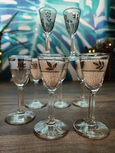 five wine glasses sitting on top of a wooden table