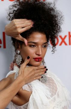 a woman with her hands on her head and nails in her hair, posing for the camera