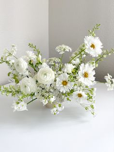 a vase filled with white flowers on top of a table