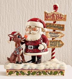 a santa clause and reindeer figurine next to a sign