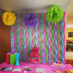 the table is set up with tissue pom - poms and other decorations on it