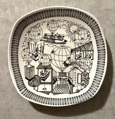 a black and white plate with an image of hot air balloons in the sky on it