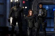 two men and a woman dressed in futuristic garb