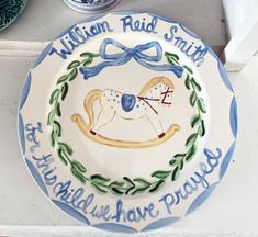 a blue and white plate with an image of a rocking horse on it, says william red smith