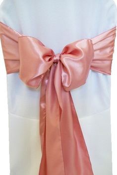 the back of a white chair with pink sashes on it's belt and bow tie