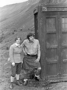 an old photo of two people standing next to a tardist in the mountains