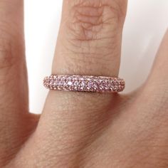 The three-row domed band is the perfect complement to any engagement ring. Wear alone, stack multiple, or pair it with any ring. This gorgeous light pink sapphire band features three rows of pave set 1.15 carats total weight circling all the way around, crafted in solid 18k rose gold. *Based on Ring size: 6.5 *Metal: Solid 18k Rose Gold *Weight: 3.05 grams *Stones: Natural Light Pink Sapphires *Stone Count: 135 PCS *Weight: 1.15 Carats Total *Band Measures: 3.5mm wide X 1.9mm thick (with +/- 0.1 Fine Jewelry Rose Gold Stackable Rings With Pave Setting, Luxury Pink Stackable Jewelry, Rose Gold Jewelry With Pave Setting In Round Band, Pink Diamond Half Eternity Band, Pink Cubic Zirconia Stackable Rings For Anniversary, Pink Half Eternity Diamond Band, Pink Cubic Zirconia Half Eternity Rings, Pink Diamond Stackable Rings With Prong Setting, Pink Eternity Band Fine Jewelry