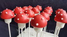 red and white cake pops are arranged on top of each other in the shape of mushrooms