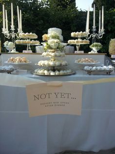 a table topped with lots of cupcakes and cake covered in white frosting