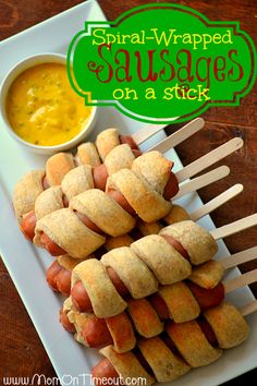 several hotdogs are arranged on sticks with dipping sauce