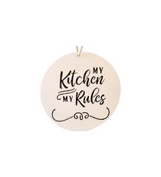 a white ceramic ornament with the words kitchen my rules printed in black on it