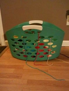 a green laundry basket sitting on top of a hard wood floor