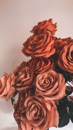 a vase filled with lots of orange roses