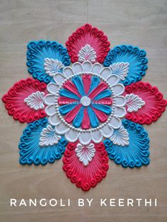 an intricately designed wall hanging made out of red, white and blue paper with the words rangoli by kerthh