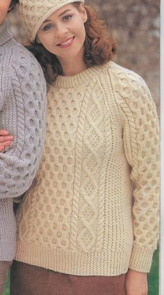 two women in knitted sweaters and hats posing for the camera with their arms around each other