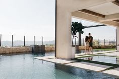 two people standing on the edge of a swimming pool