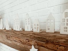 white candles are lined up on a mantle